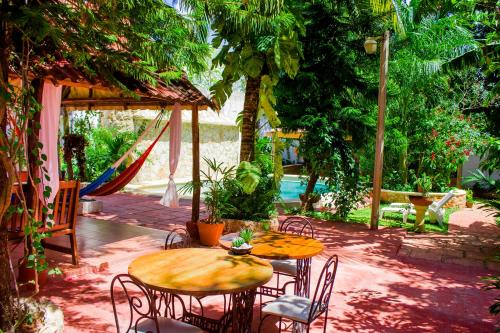 a patio with two tables and chairs and a swing at Casa De Los Pájaros - B&B in Valladolid