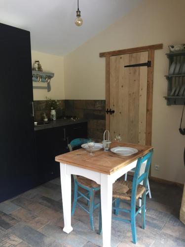 une cuisine avec une table et deux chaises ainsi qu'une porte dans l'établissement GoGreen Cabin, à Saint-Priest-les-Fougères