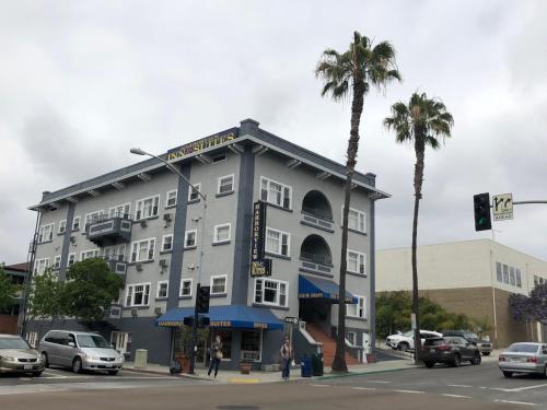 a large gray building with palm trees on a street at Harborview Inn & Suites-Convention Center-Airport-Gaslamp-Seaworld-Zoo-Balboa Park in San Diego