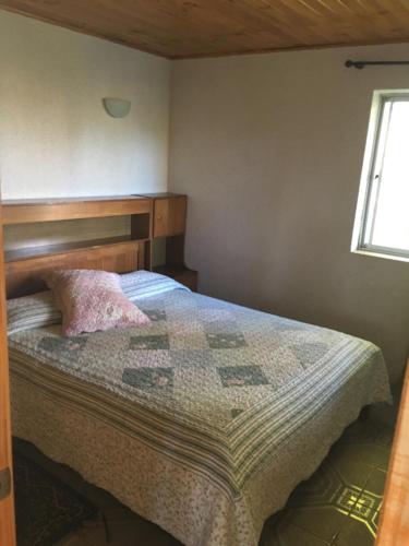 una camera da letto con un letto con una trapunta sopra di Cabañas y Camping Playa Hermosa a Los Ángeles