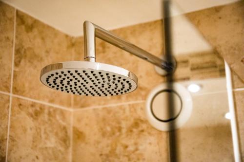 a shower with a shower head in a bathroom at Wisteria Hotel in Oakham