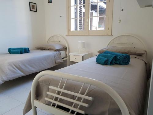 a bedroom with two beds with blue pillows on them at Guest House Adele in Marina di Ragusa