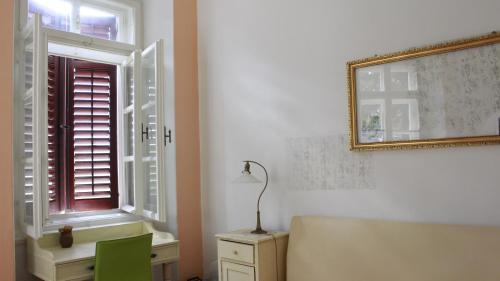 Zimmer mit einem Fenster, einem Schreibtisch und einer Lampe in der Unterkunft In the center & nice & quiet in Pula