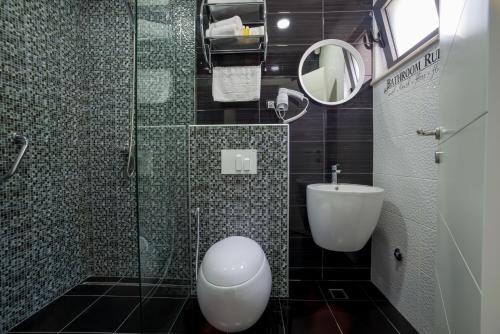 a bathroom with a toilet and a glass shower at StOliva RESIDENCE with infinity pool in Kotor