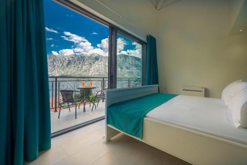 a bedroom with a bed and a large window at StOliva RESIDENCE with infinity pool in Kotor