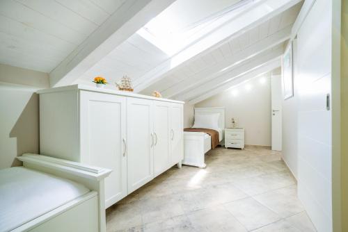 a attic bedroom with white cabinets and a bed at StOliva RESIDENCE with infinity pool in Kotor