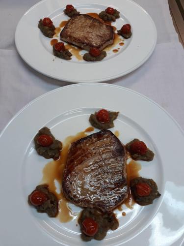 two plates of food with meat and berries on them at Kuko Hotel - Adults Only in Oronoz-Mugaire