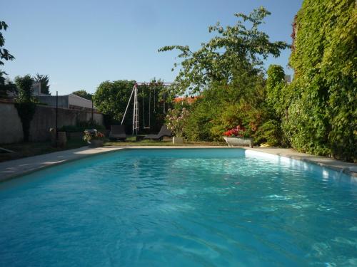 una piscina de agua azul en un patio en La Vigne Vierge, en Châteauneuf-sur-Loire
