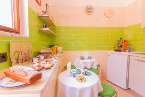 a kitchen with two tables and green tiles at B&B Sotto un Tetto in Cetara