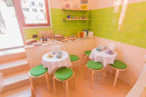 a small room with two tables and green chairs at B&B Sotto un Tetto in Cetara