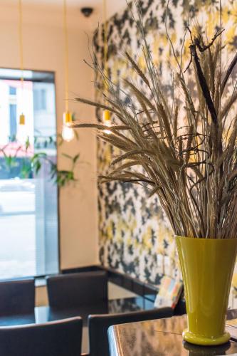 a yellow vase sitting on a table with chairs at Cinelandia Hotel in Sao Paulo