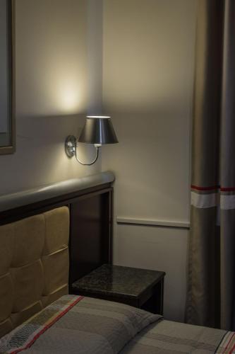 a bedroom with a bed and a lamp on the wall at Soneca Plaza Hotel in Sao Paulo
