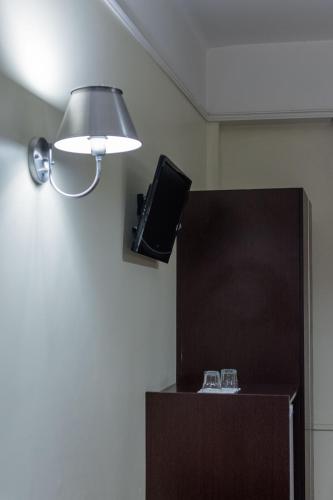 a room with a lamp and a television on a wall at Soneca Plaza Hotel in Sao Paulo
