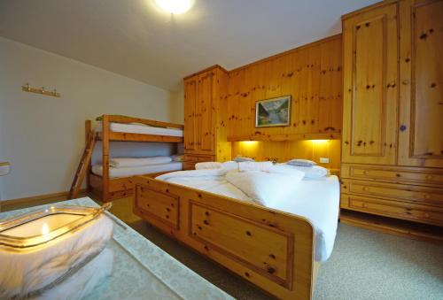 a bedroom with two beds and a bunk bed at Piz da Cir in Colfosco
