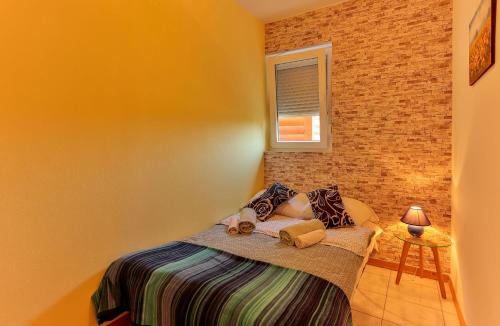 a bedroom with a bed and a brick wall at Apartments Dora Victoria Dream in Medulin