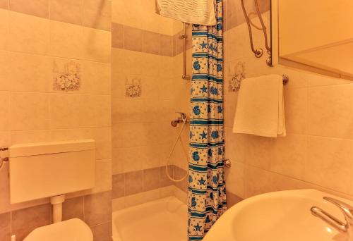 a bathroom with a white toilet and a sink at Apartments Dora Victoria Dream in Medulin
