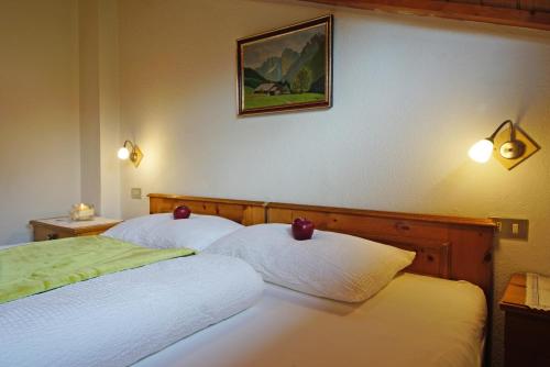 two beds in a hotel room with a picture on the wall at Piz da Cir in Colfosco
