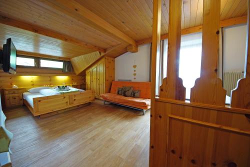 a bedroom with a bed and a couch in a room at Piz da Cir in Colfosco