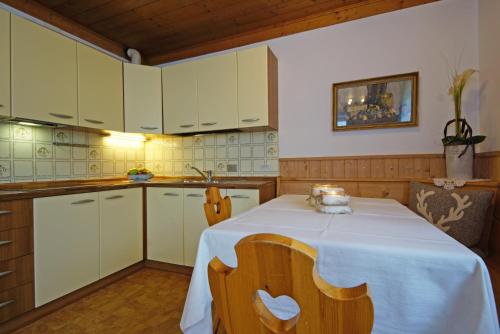 a kitchen with a table with a white table cloth at Piz da Cir in Colfosco
