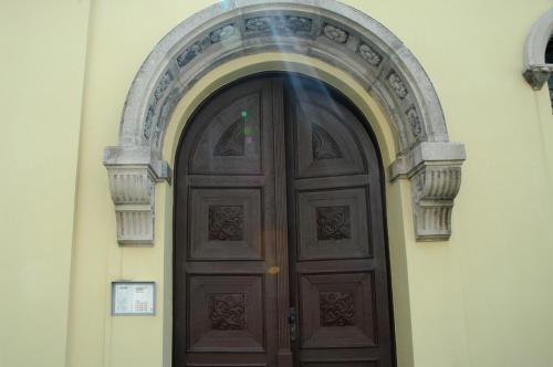 a wooden door in a building with an arch at STM3 Apartman in Pécs