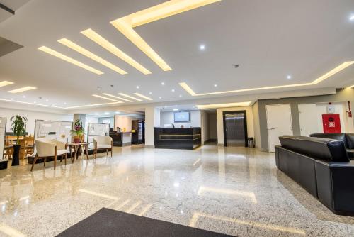 a lobby with chairs and a table in a building at Prime Hotel Ponta Porã in Ponta Porã