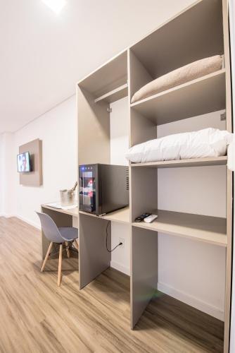 a room with a bunk bed and a desk at Prime Hotel Ponta Porã in Ponta Porã
