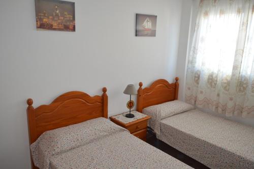 1 dormitorio con 2 camas y ventana en Hnos Navarrete, en Fuengirola