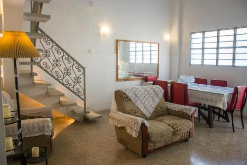 a living room with a staircase and a chair and a table at Hostal Corona in Havana
