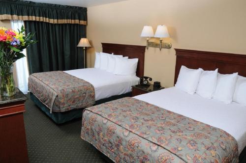 a hotel room with two beds and a vase of flowers at Pike's Waterfront Lodge in Fairbanks