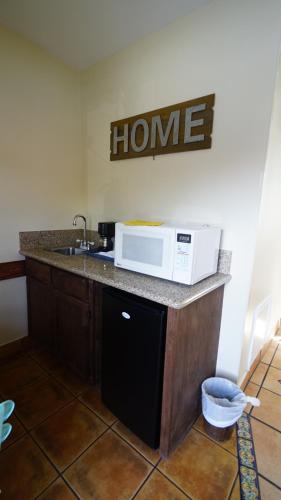 a kitchen with a sink and a microwave on a counter at Villa Brasil Motel in Los Angeles