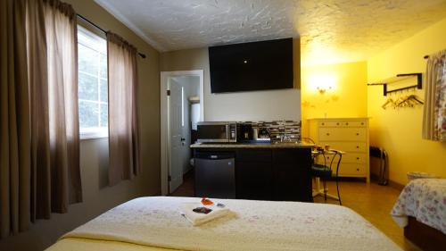 a hotel room with a bed and a kitchen at Villa Brasil Motel in Los Angeles