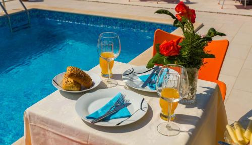 a table with plates of food and a vase of flowers at Apartments Dora Victoria Dream in Medulin