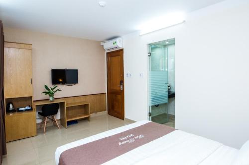 a bedroom with a bed and a desk and a tv at Hoa Phuong Hotel in Hai Phong