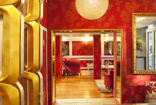 einen Flur mit einem Spiegel und einer roten Wand in der Unterkunft Hotel Louvre Bons Enfants in Paris