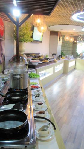 a kitchen with a counter with plates and a stove at Kim Tho Hotel in Can Tho