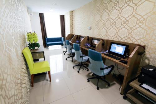 a conference room with a desk with a laptop and chairs at Odua Weston Jambi in Jambi