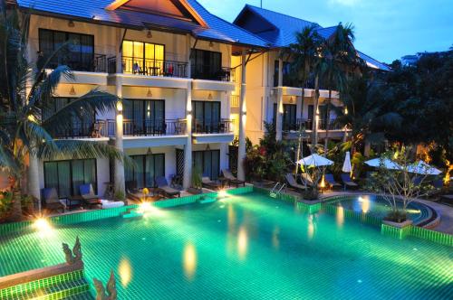 a swimming pool in front of a hotel at Navatara Phuket Resort - SHA Extra Plus in Rawai Beach