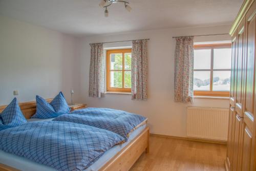 1 dormitorio con 1 cama y 2 ventanas en Ferienwohnungen Ilsanker - Doffenlehen, en Marktschellenberg