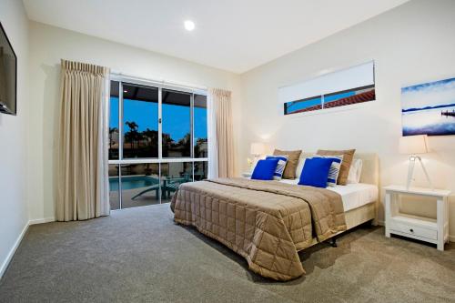 a bedroom with a bed and a large window at Sandy Cove in Gold Coast