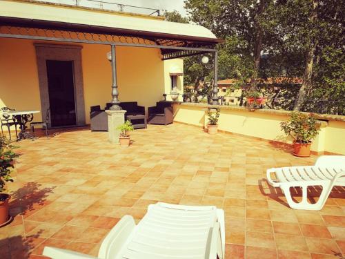 a large patio with white chairs and a table at Hotel Royal in Bolsena