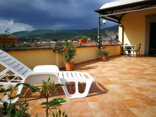 a balcony with white chairs and a view of a city at Hotel Royal in Bolsena