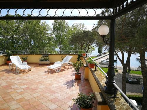 a patio with white chairs and a street light at Hotel Royal in Bolsena