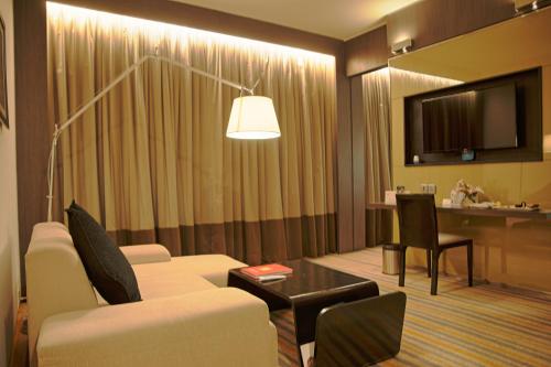 a living room with a couch and a table at Novotel Kolkata Hotel and Residences in Kolkata