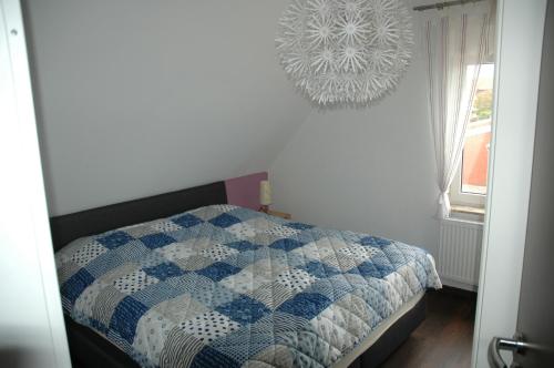 a bedroom with a blue and white quilt on a bed at Huus Veertein in Neuharlingersiel