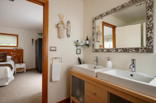a bathroom with two sinks and a mirror at Paku Palms in Tairua