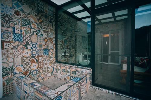 een badkamer met een muur bedekt met kleurrijke tegels bij Look Bed and Breakfast in Yuchi