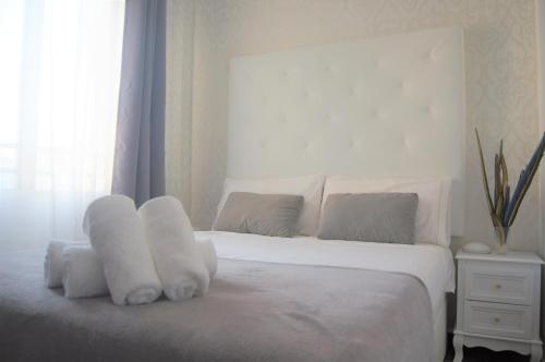 ペニスコラにあるHello Peñiscola Boutique Apartmentの白い枕と窓が備わる白いベッド