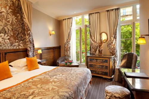 une chambre d'hôtel avec un lit et une chaise dans l'établissement Au Manoir Saint Germain, à Paris