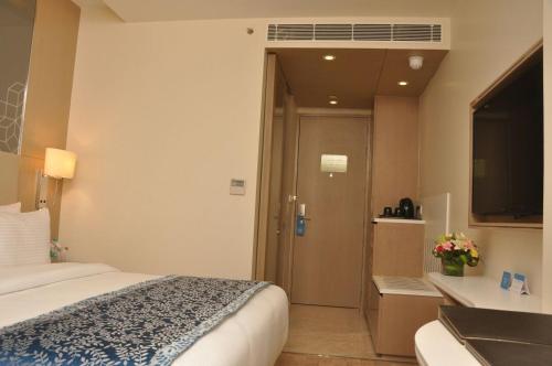 a hotel room with a bed and a bathroom at Days Hotel Jaipur Tonk Road By Wyndham in Jaipur