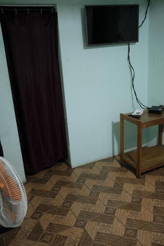 Cette chambre dispose d'une télévision, d'une table et d'un sol. dans l'établissement Hostal del Este Santa Fe, à San José